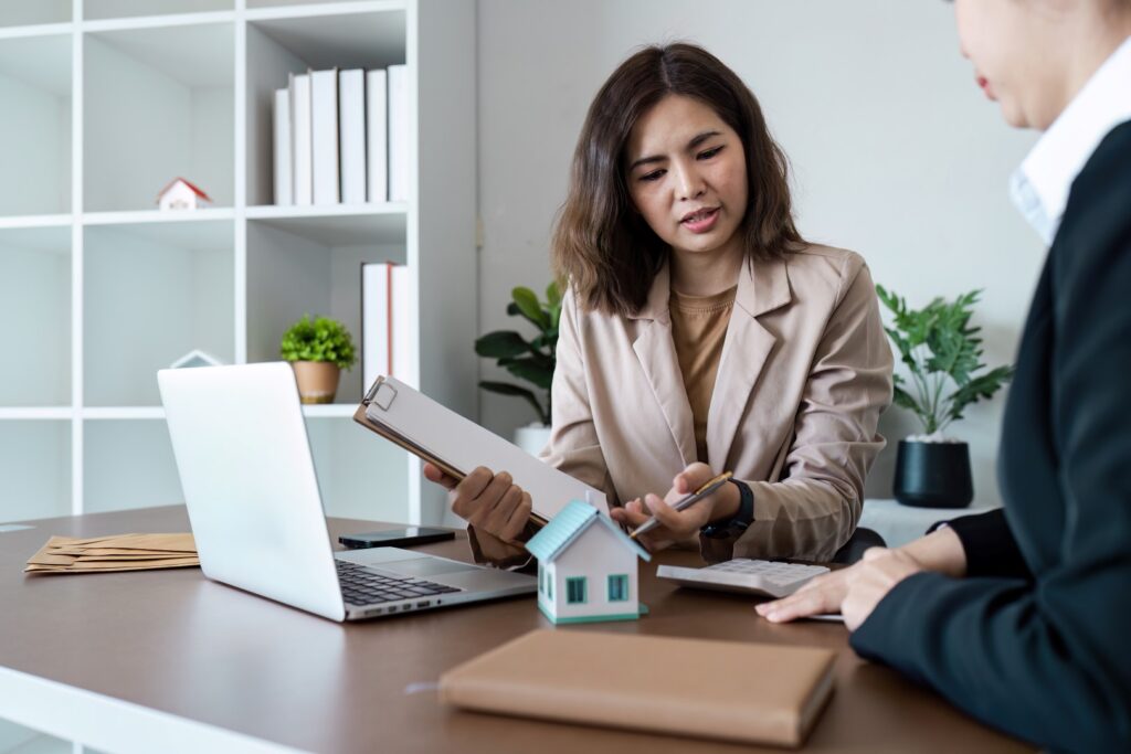 Real estate agent reviewing home inspection paperwork with client.